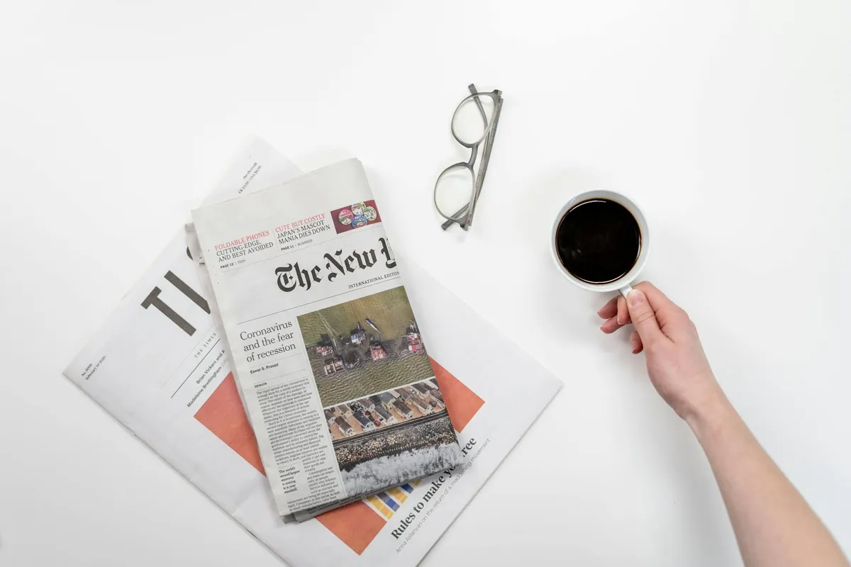 A casual morning desk setup with newspaper and coffee
